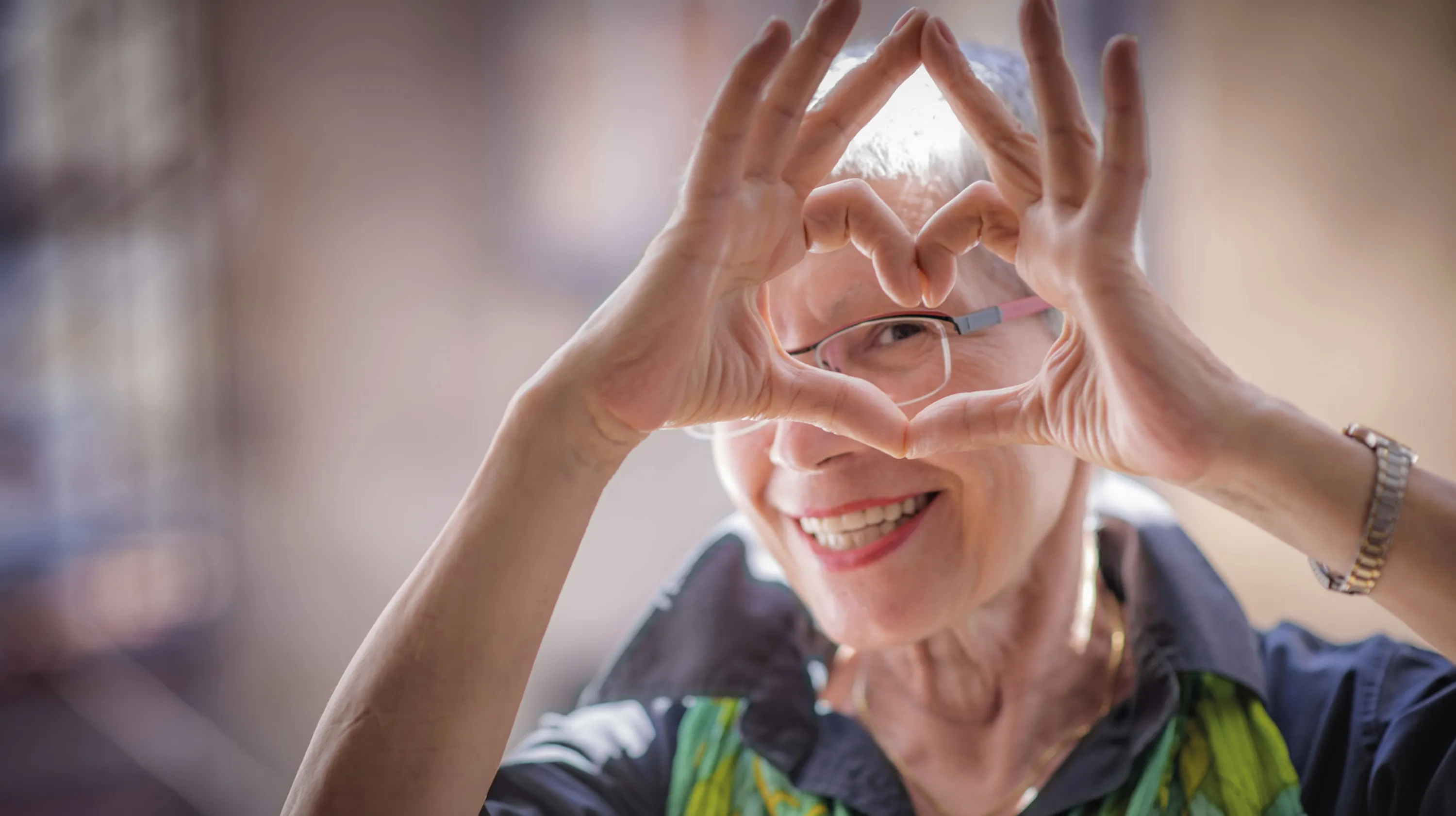 signora frontale con occhiali cuore con le dita